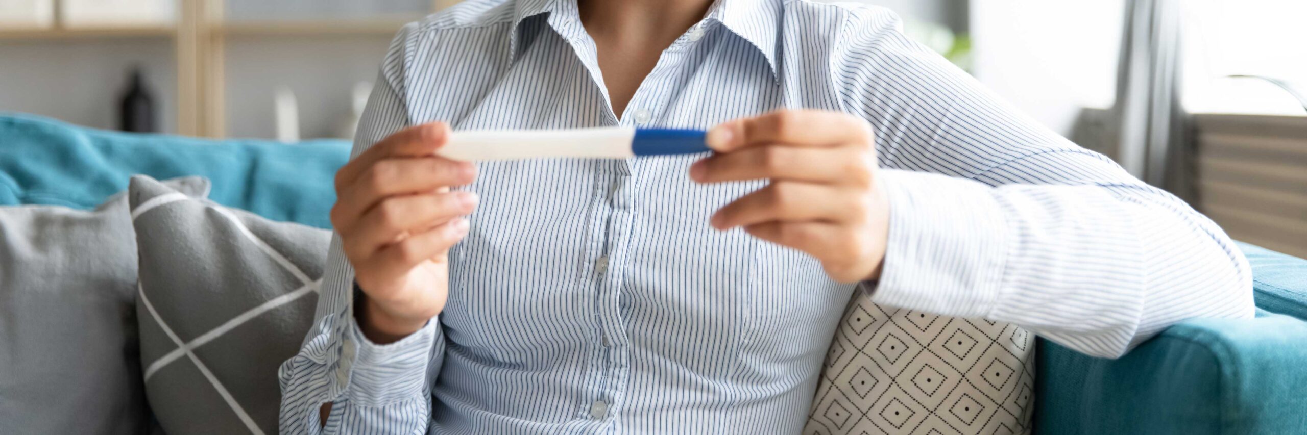 Woman looks at pregnancy test after an IUI treatment at Envita Fertility Center | Laguna Hills & Orange County, CA