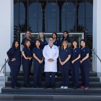 Envita Fertility Center staff standing in two rows in front of the Taj Mahal Medical Center in Orange County, CA