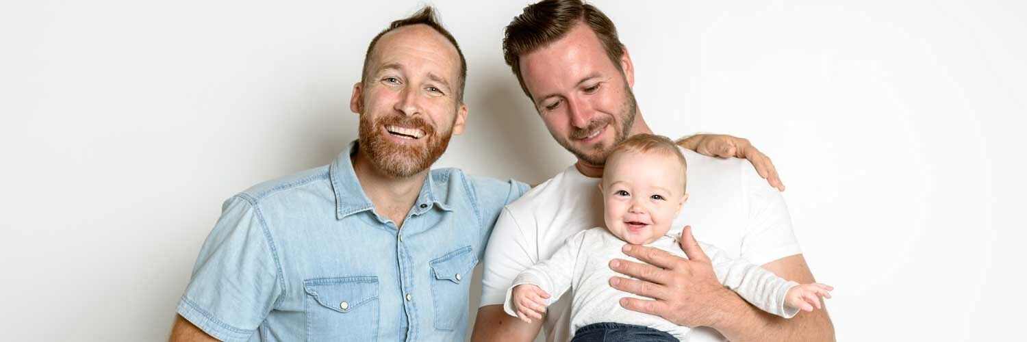 Two Dads holding baby conceived using LGBTQ+ fertility services | Envita Fertility Center, Orange County